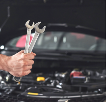 mechanic-holding-pair-wrenches-repair-garage