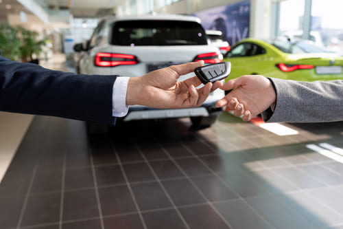 Consultor de concessionária de carros entregando as chaves para o comprador. Foto: Freepik Consultor de concessionária de carros entregando as chaves para o comprador. Foto: Freepik